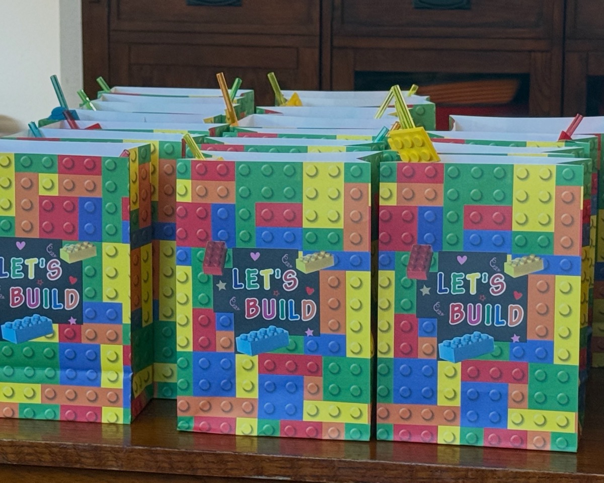 Rows of "Let's Build" goodie bags lined up and ready for guests to take home