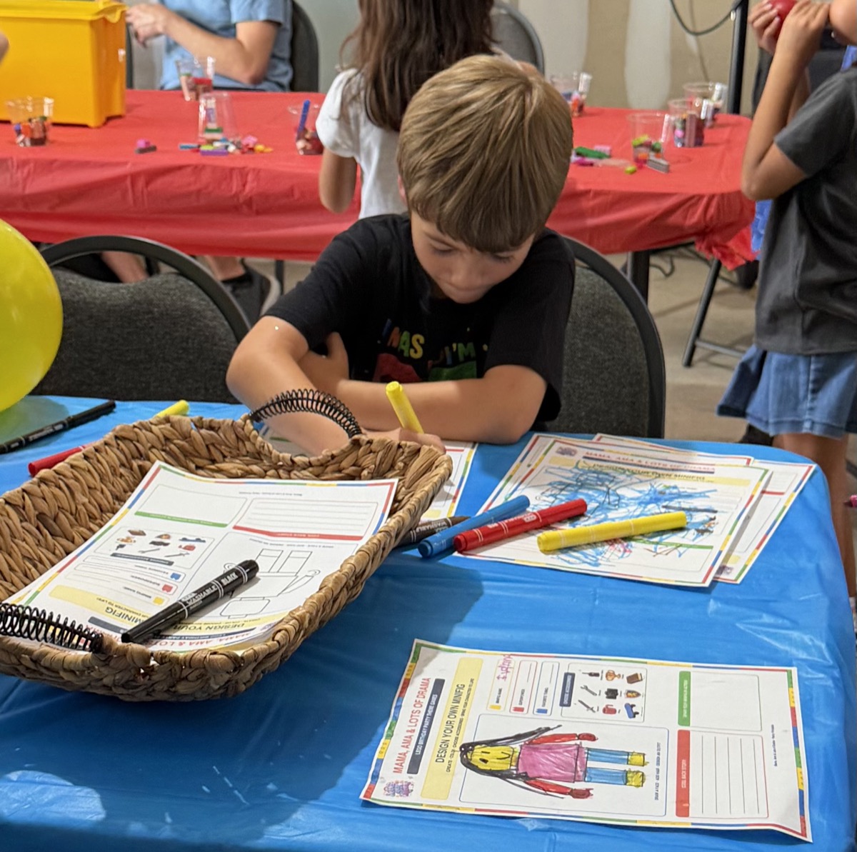 Our birthday boy carefully coloring his own Design Your Own Minifig printable at the craft table